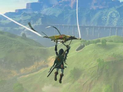 Screenshot of Link from The Legend of Zelda: Tears of the Kingdom. He is soaring over a grassy plain on his Tears of the Kingdom Paraglider.