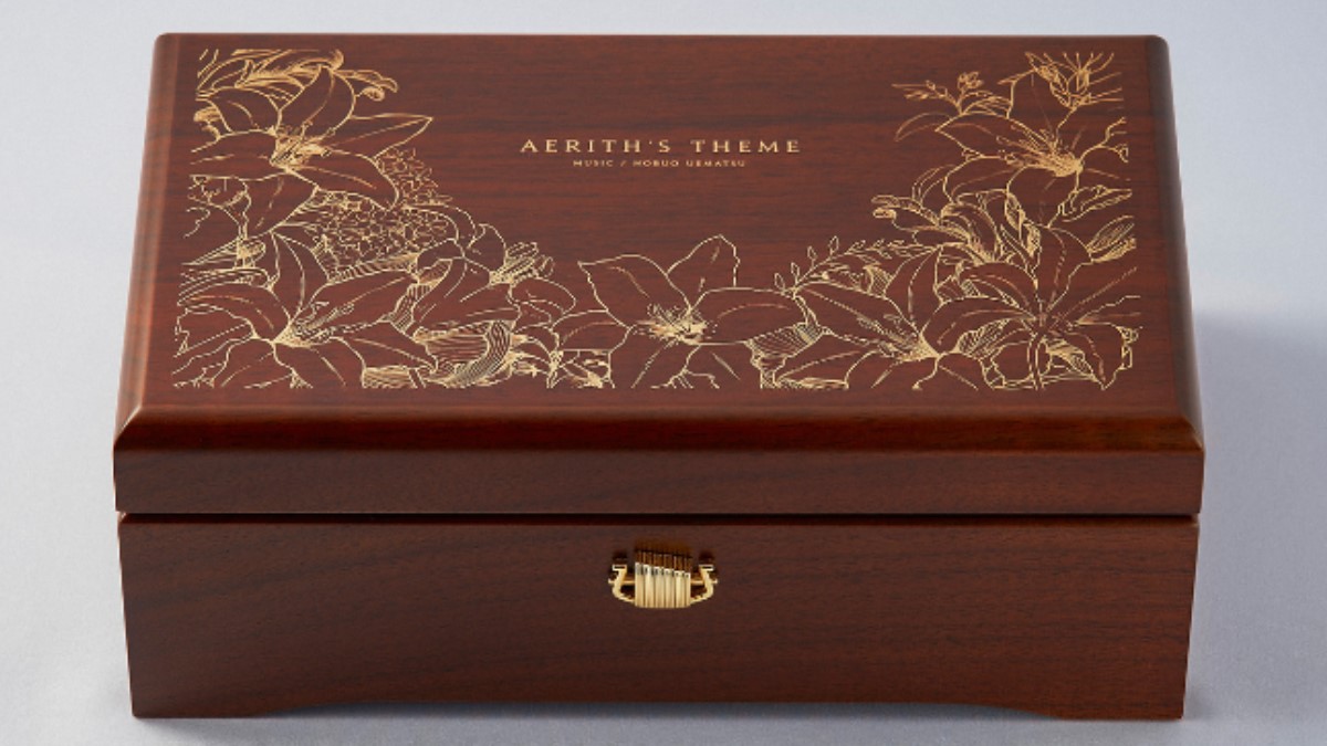 A wooden music box with golden flower engravings.