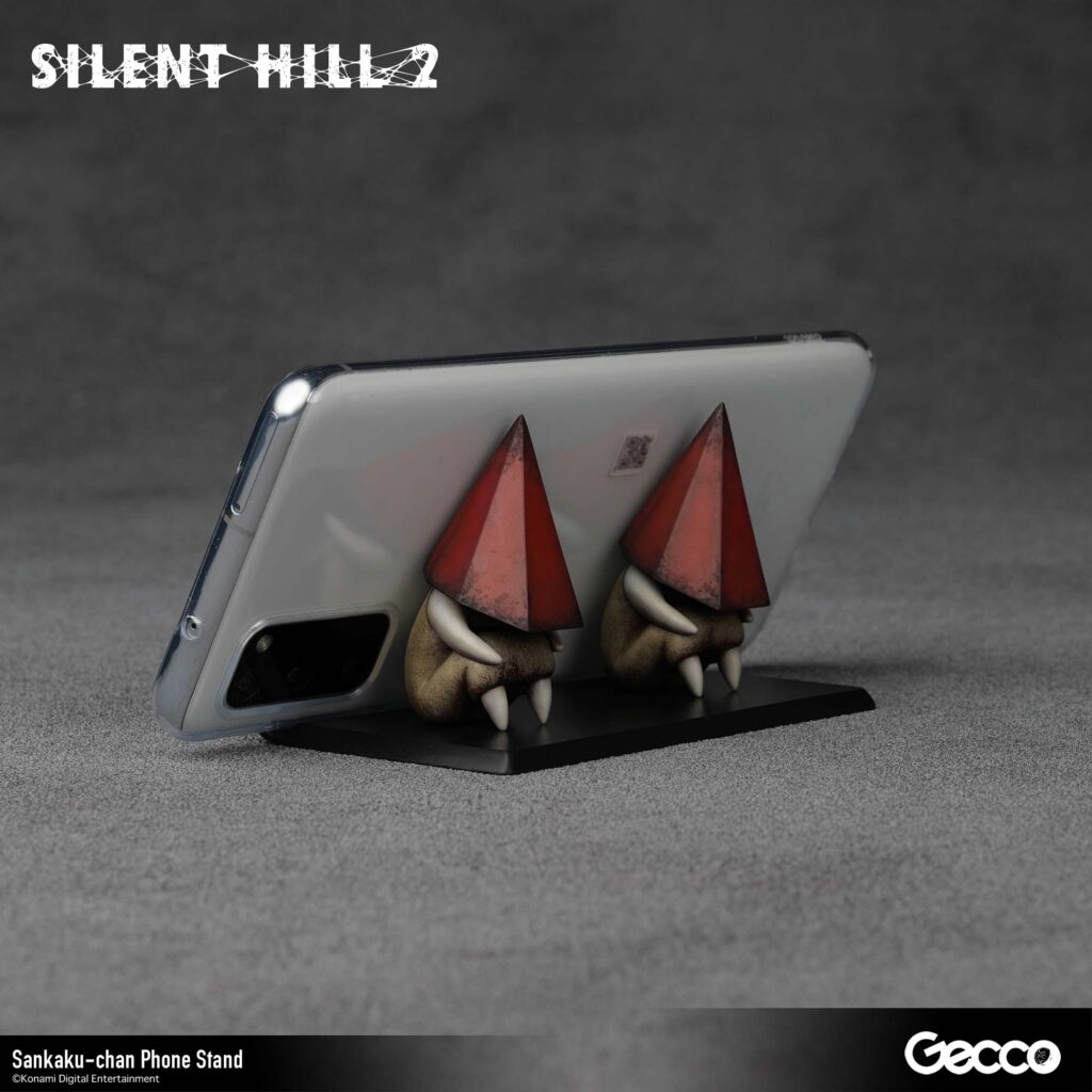 The next Gecco Silent Hill 2 merchandise will be a Sankaku-chan phone stand with two tiny red Pyramid Head figures. 