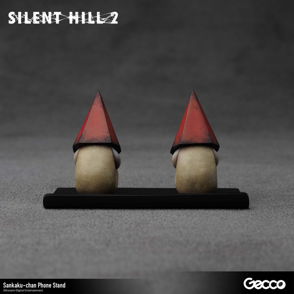 The next Gecco Silent Hill 2 merchandise will be a Sankaku-chan phone stand with two tiny red Pyramid Head figures. 