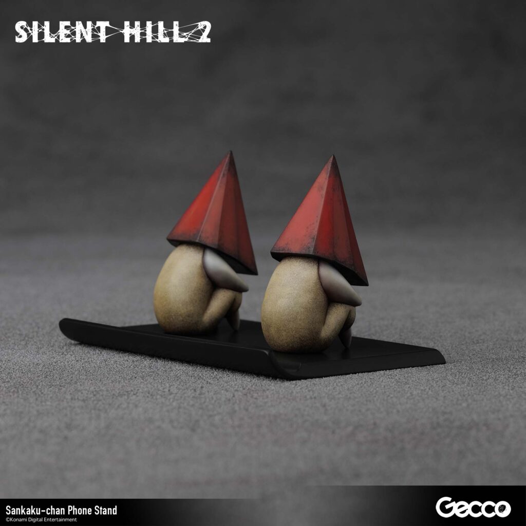 The next Gecco Silent Hill 2 merchandise will be a Sankaku-chan phone stand with two tiny red Pyramid Head figures. 
